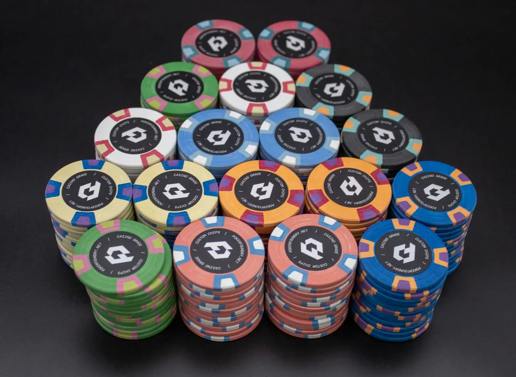 Custom clay chips with personalised logo artwork on printed inlays and traditional casino-style edge spots