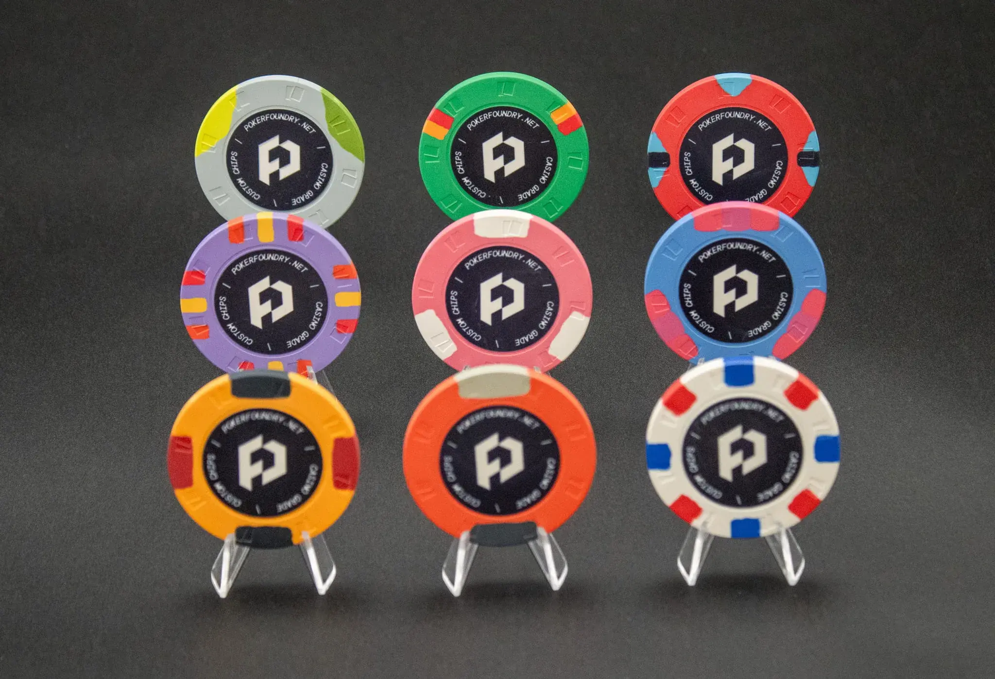 Full denomination set of custom ceramic poker chips arranged by colour and value on a poker table