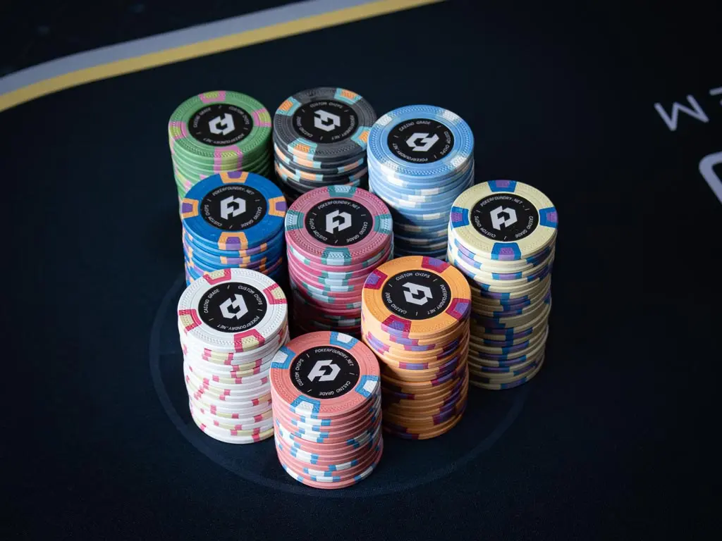 Close-up of 10g custom clay poker chips with high-resolution printed label inlays and classic bevelled edges
